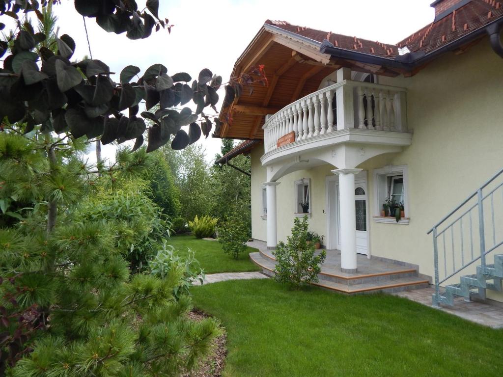 a white house with a balcony and a yard at Rooms Ambrožič in Bled