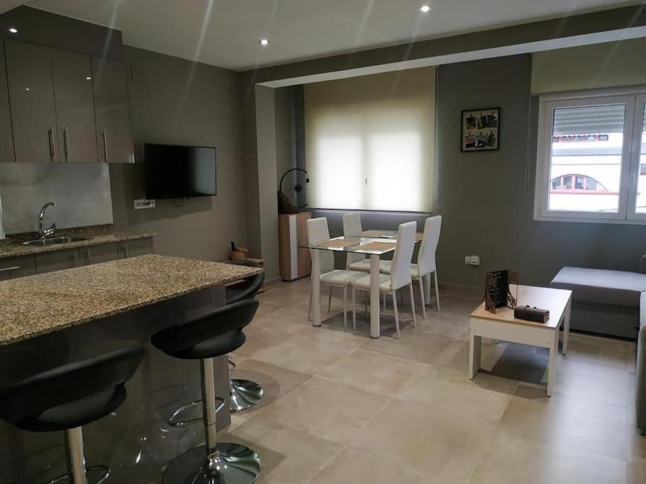 a kitchen and living room with a table and chairs at APARTAMENTOS CAMINO A RIBEIRA in Quiroga