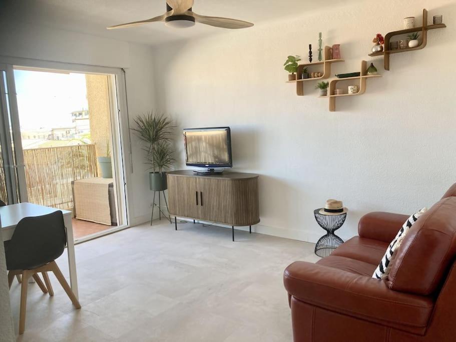 un salon avec un canapé et une télévision dans l'établissement Cap au sud !, à Narbonne-Plage