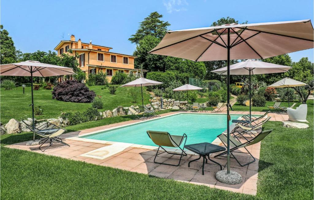 einen Pool mit Stühlen und Sonnenschirmen vor einem Haus in der Unterkunft Castagno in Capranica
