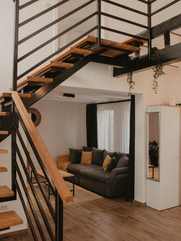 a living room with a couch and a staircase at HomyHouse in Sibiu