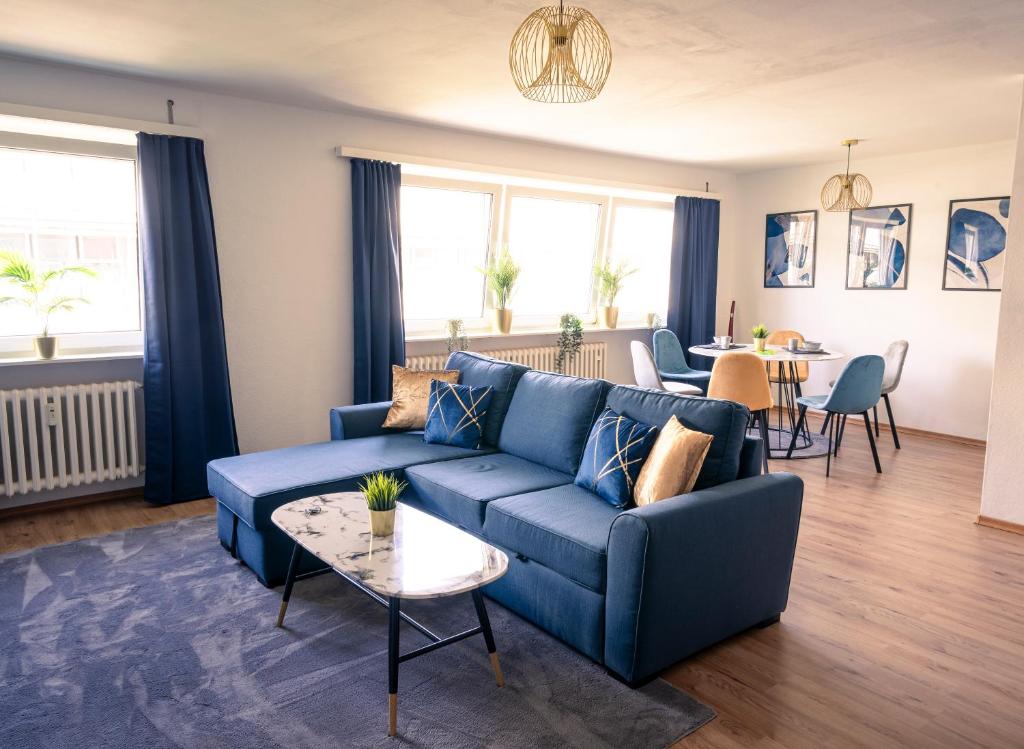 sala de estar con sofá azul y mesa en City Loft - 5 Min Rhein-Galerie, en Ludwigshafen am Rhein