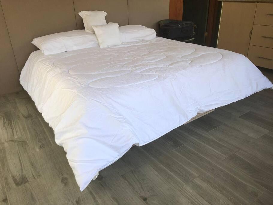 1 cama blanca grande con sábanas y almohadas blancas en Cabaña de montaña espectacular, en Liberia