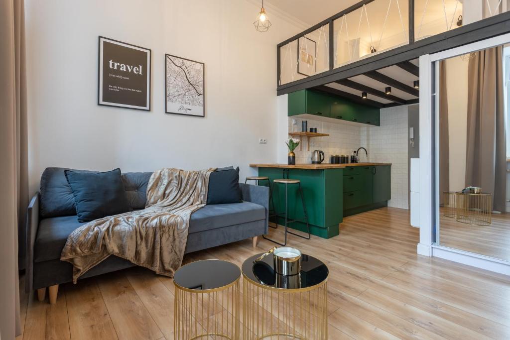 a living room with a couch and a kitchen at Golden Apartments Warsaw - Stylish Luxury, Złota Street in Warsaw