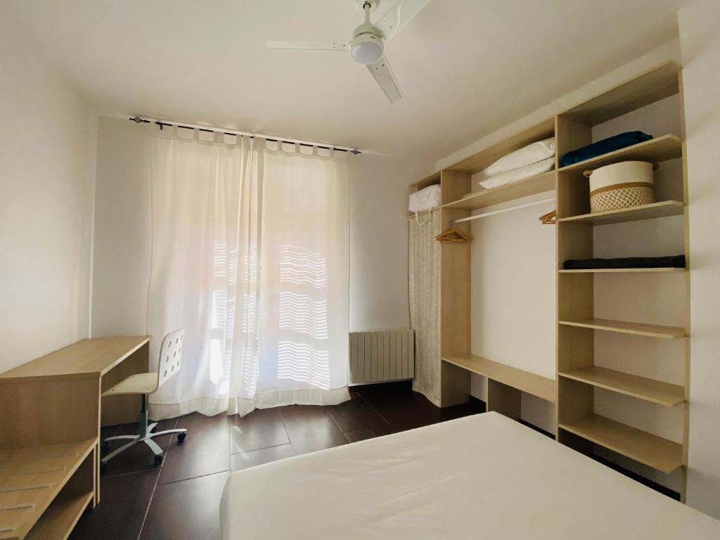 Zimmer mit einem Bett, einem Fenster und einem Schreibtisch in der Unterkunft La Fonda de la Calle Ancha in Guadix