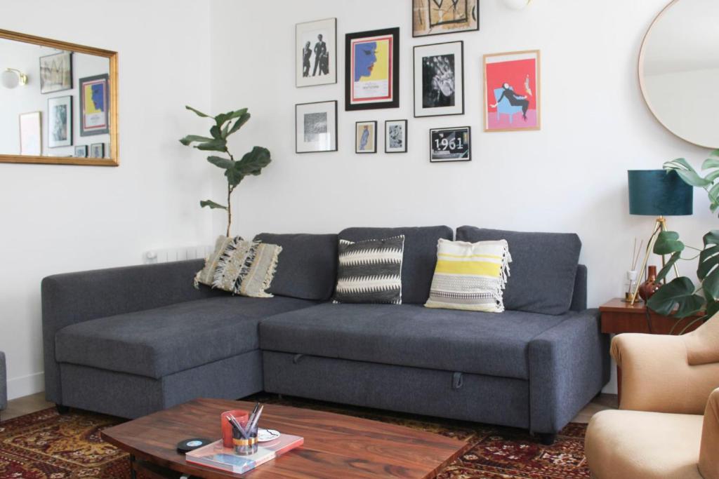 a living room with a gray couch and a table at Luminous cocoon in Aubervilliers in Aubervilliers