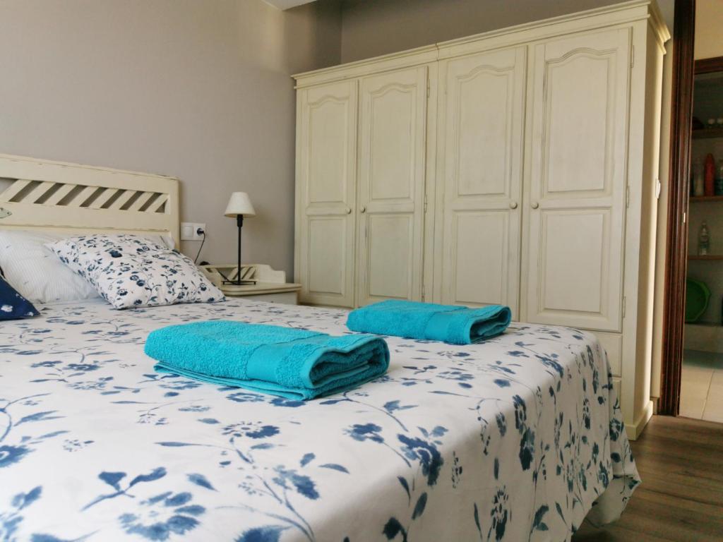 um quarto com uma cama com duas almofadas azuis em San Pedro em Cangas de Foz