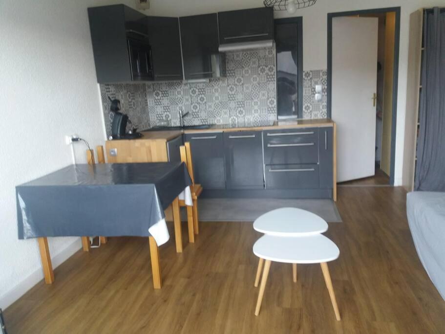 une cuisine avec une table bleue et une chaise blanche dans l'établissement Appartement pieds des pistes au Pla d'Adet à Saint Lary Soulan, à Saint-Lary-Soulan