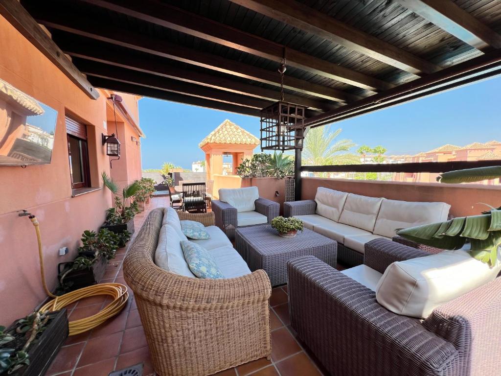 een patio met banken en stoelen op een balkon bij PUSHE Penthouse Playa Granada Beach & Golf 2 in Motril