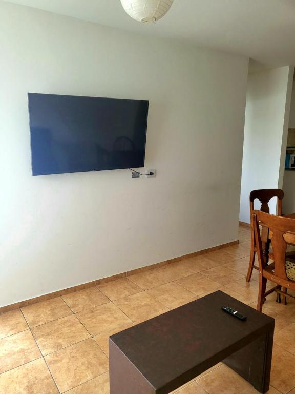 a living room with a tv on a white wall at SLC Maipú in San Luis