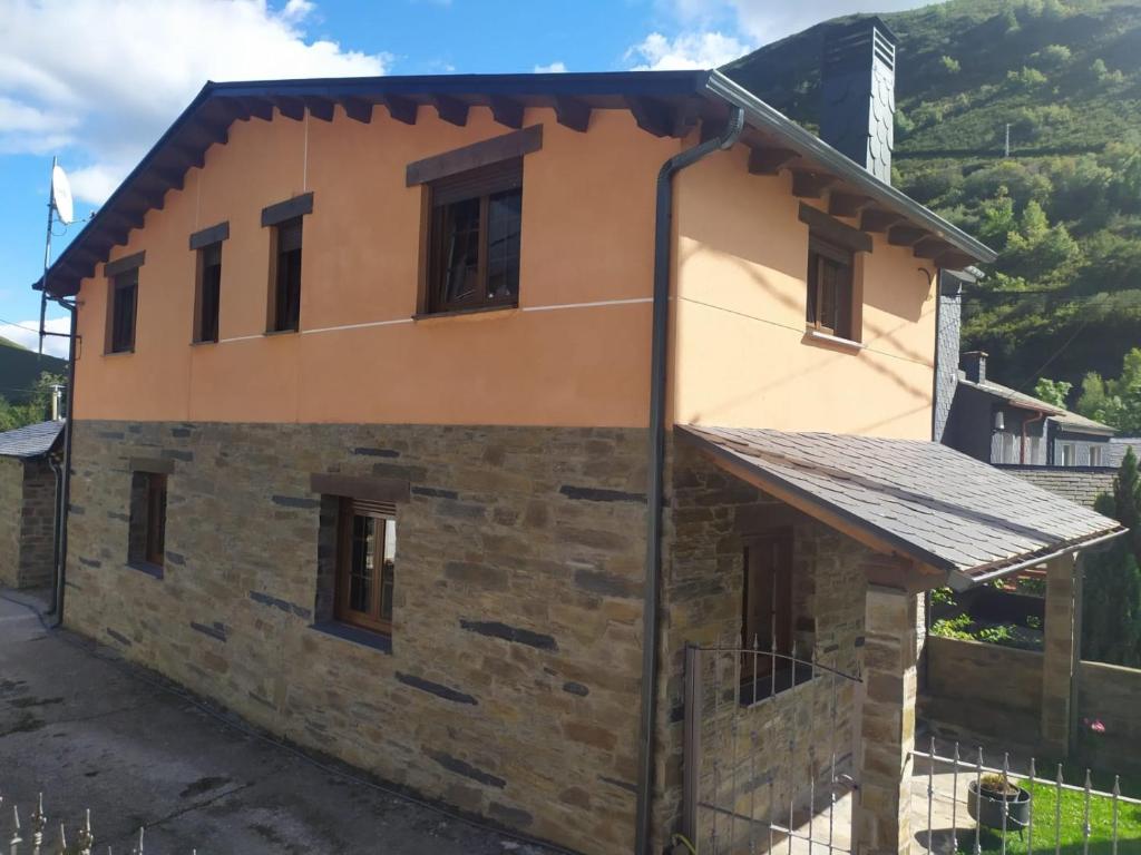 uma casa nas montanhas com um edifício em Casa Miravalles Fornela 