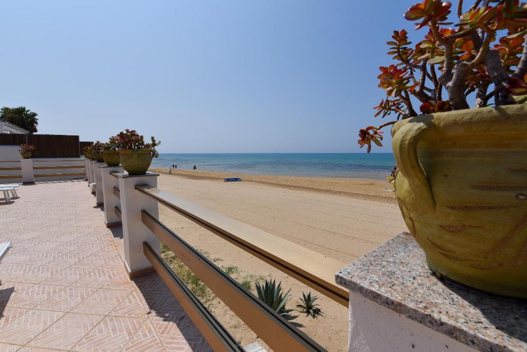a view of a beach with a vase on a fence at Le Sorelle Villa sul mare in Porto Empedocle