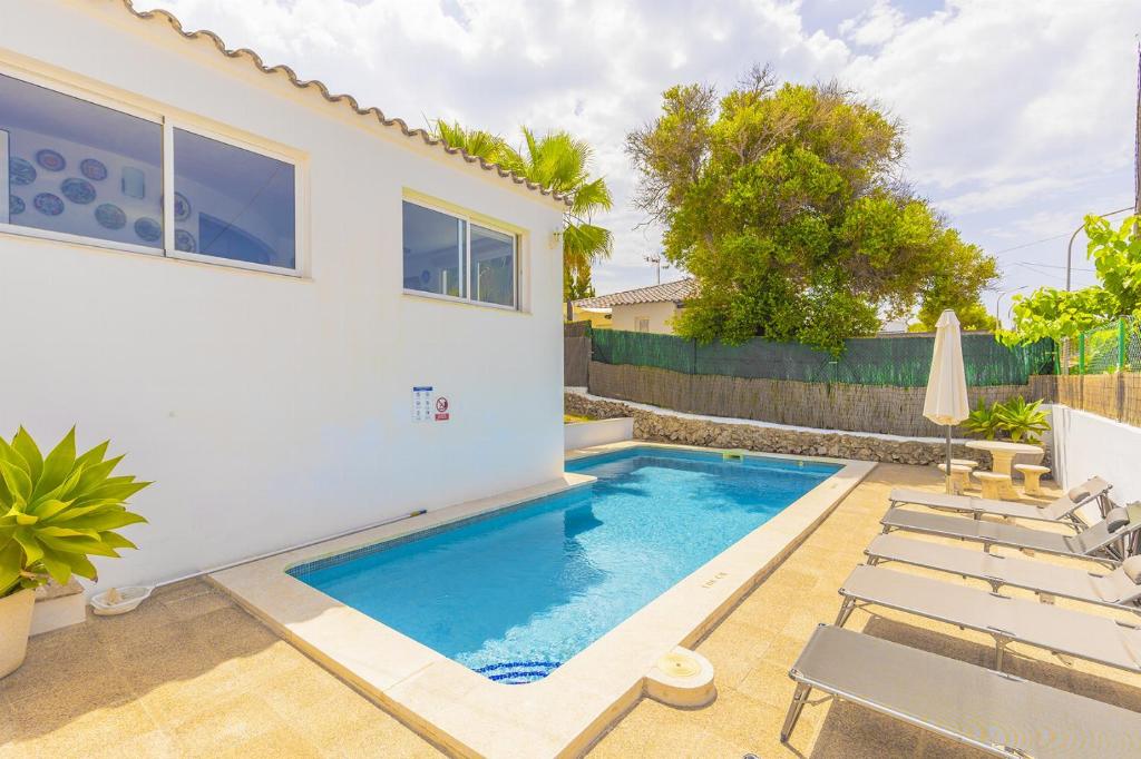 a swimming pool in the backyard of a house at Villa Palmera in Alaior