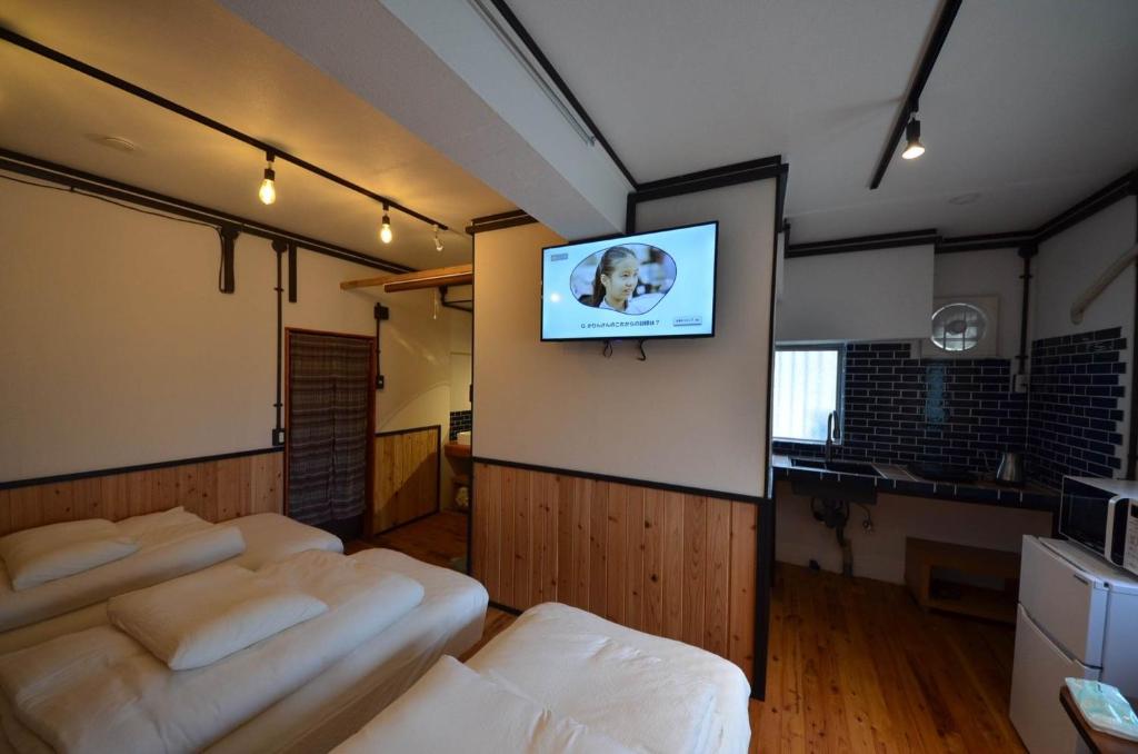 a room with a bunch of chairs and a tv on a wall at GRANDPA'S HOUSE Barchanchi - Vacation STAY 53569v in Naha