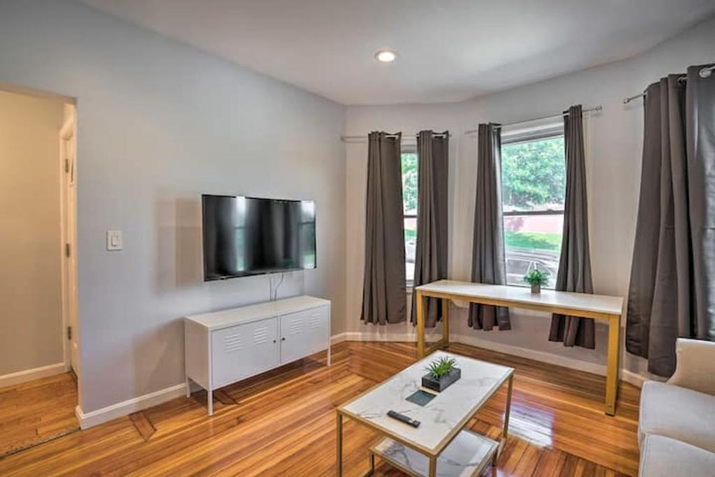 a living room with a flat screen tv on a wall at Astonishing 4BR Bright *Apt with modern amenities! in Boston