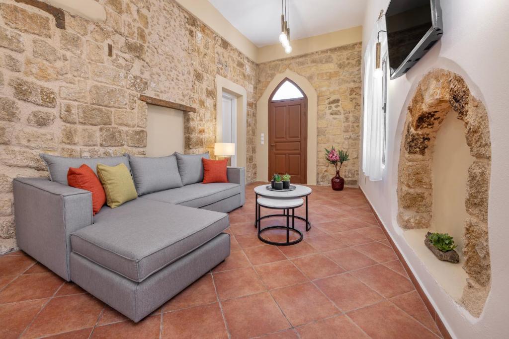 a living room with a couch and a stone wall at Nikolas Old Town in Rhodes Town