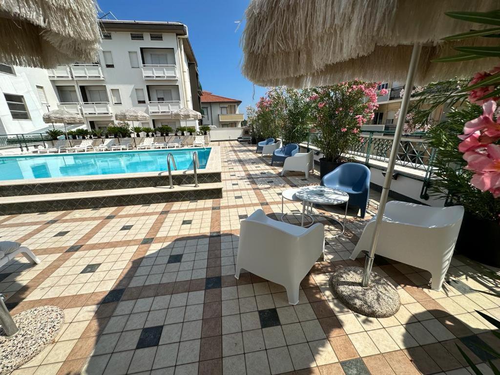 una fila de sillas y sombrillas junto a una piscina en Hotel Costa Verde, en Pineto