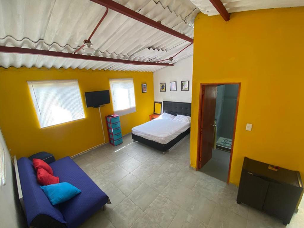 sypialnia z łóżkiem i kanapą w pokoju w obiekcie Colors House w mieście Fusagasugá