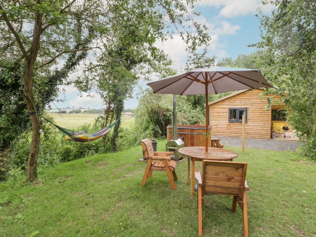 a hammock and a table and chairs under an umbrella at Dragonfly in Rugby