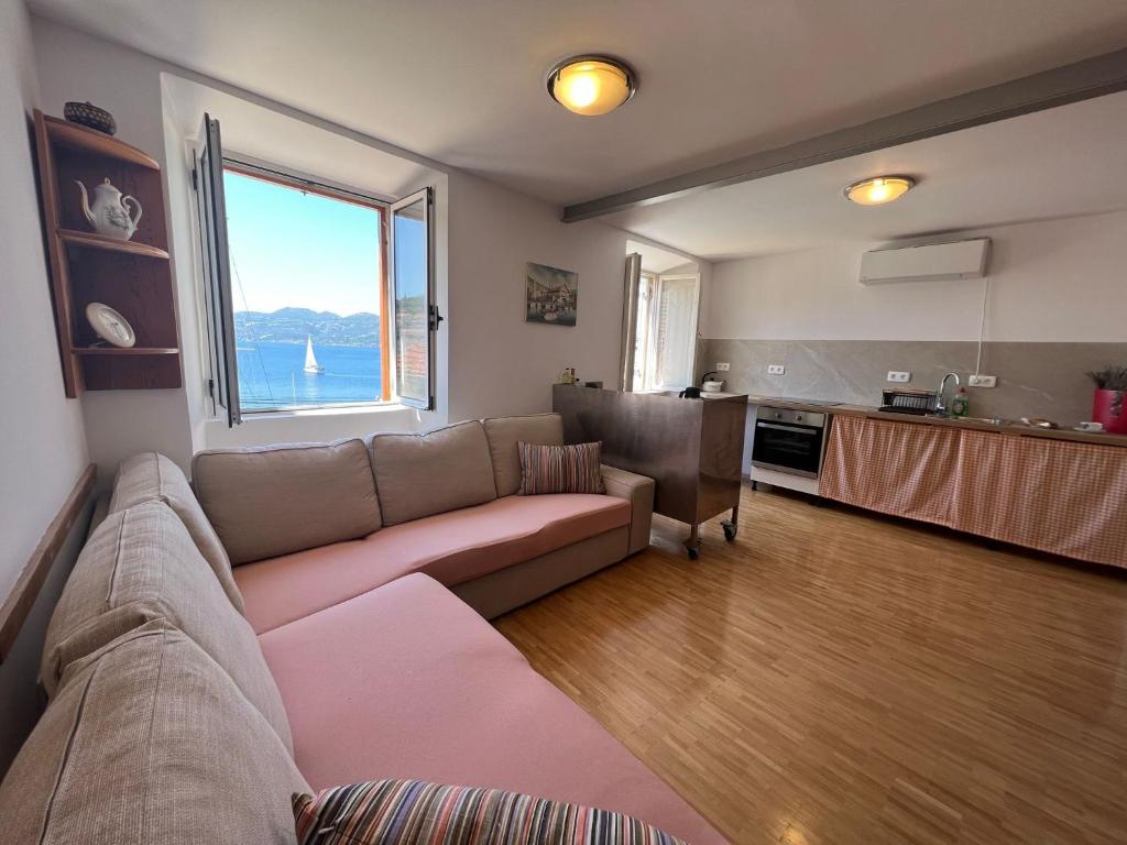 ein Wohnzimmer mit einem Sofa und einer Küche in der Unterkunft Apartman Aterina in Korčula