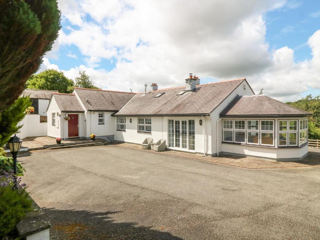 ein großes weißes Haus mit vielen Fenstern in der Unterkunft Bwthyn Clai in Llangefni