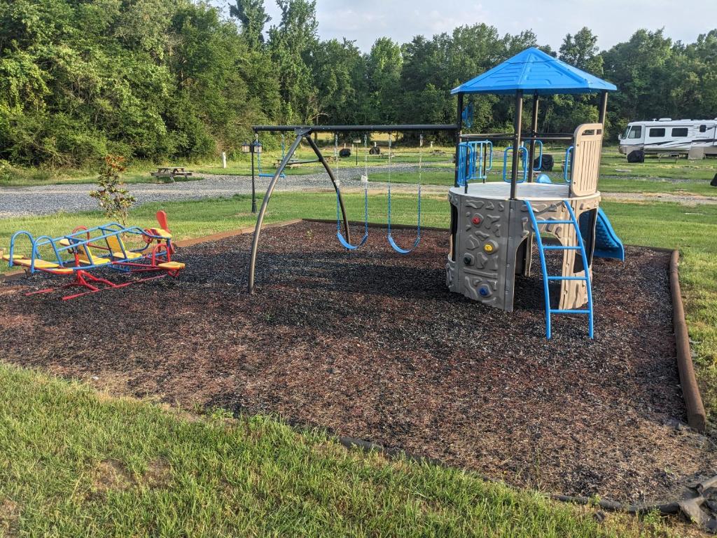 a playground with a play equipment in a yard at Chigger Hill RV Park in Hatfield