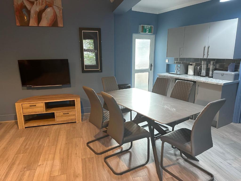 een eetkamer met een tafel en stoelen en een keuken bij The Angel Inn in Troed-y-rhiw