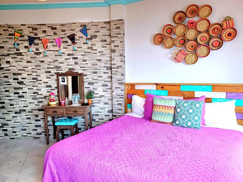 a bedroom with a pink bed and a table at Casa El Ombligo de la Luna in Guanajuato