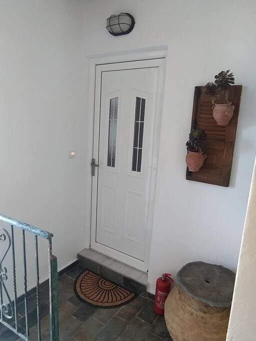 a white door in a white room with a stair case at Sergi Home in Raches