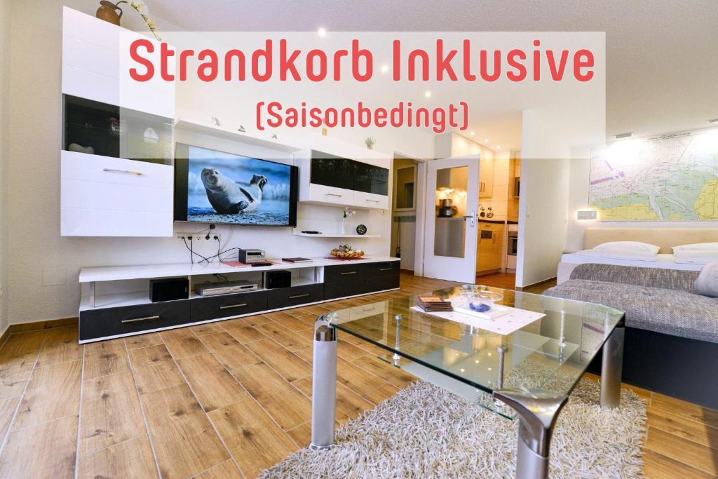 uma sala de estar com uma mesa de vidro e uma televisão em Strandhochhaus SHC3 em Cuxhaven