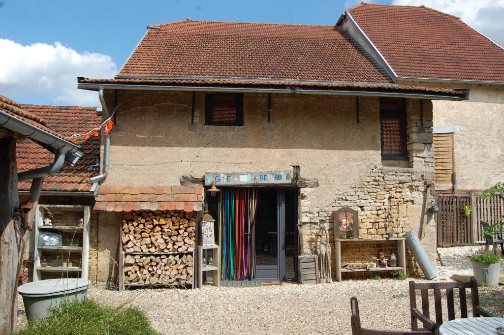 a building with a store with a pile of wood at Gite Juste Confortable in Fleurey-lès-Lavoncourt