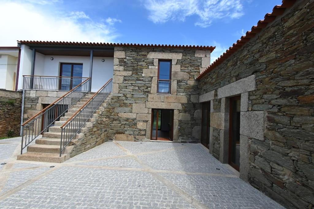 un edificio de piedra con una escalera junto a un edificio en Casa de Trás-o-Muro, en Vila Real