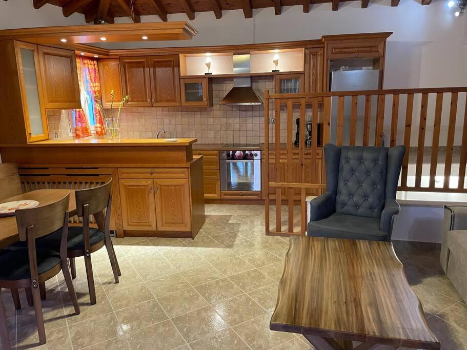 a kitchen with wooden cabinets and a table and a chair at Like my house in Skiathos