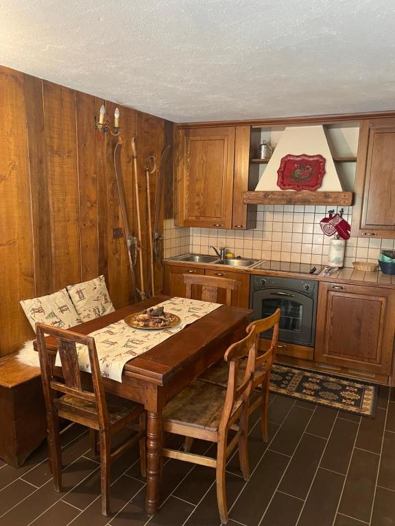 a kitchen with a wooden table and chairs at Cozy Apartment Ruitor in La Thuile