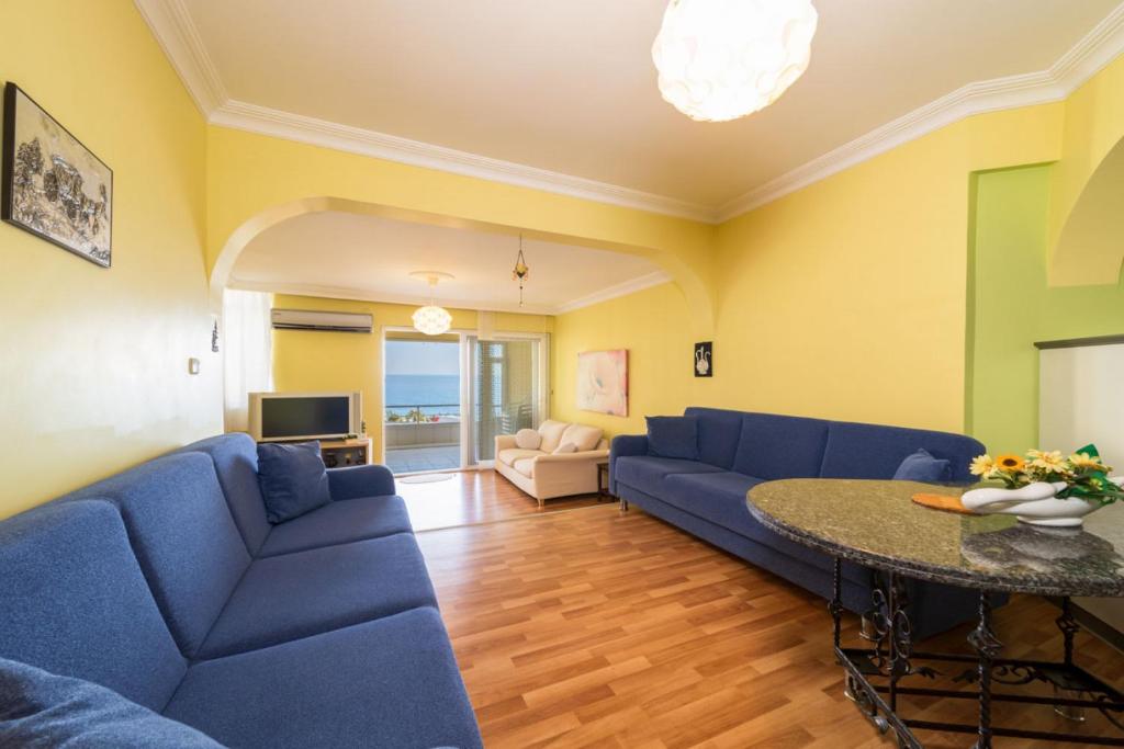 a living room with blue couches and a table at Pleasant Flat near Beach with Sea View in Alanya in Kargicak