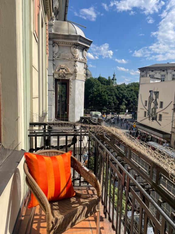 una almohada naranja sentada en una silla en un balcón en AVANTI Family, en Cracovia