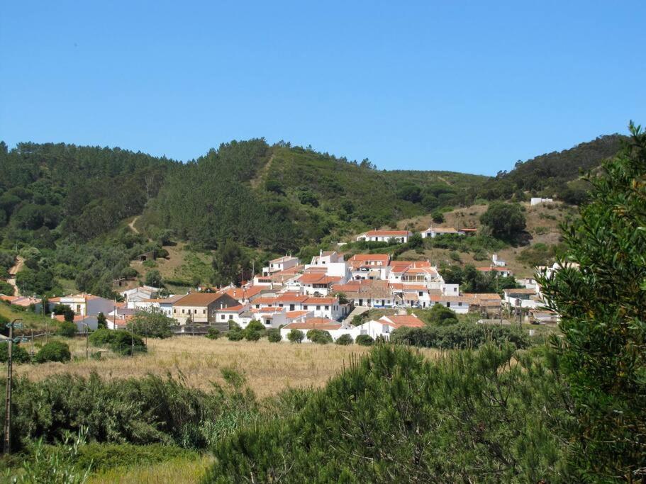 un pueblo al lado de una colina con casas en Casa das Flores, en Bordeira