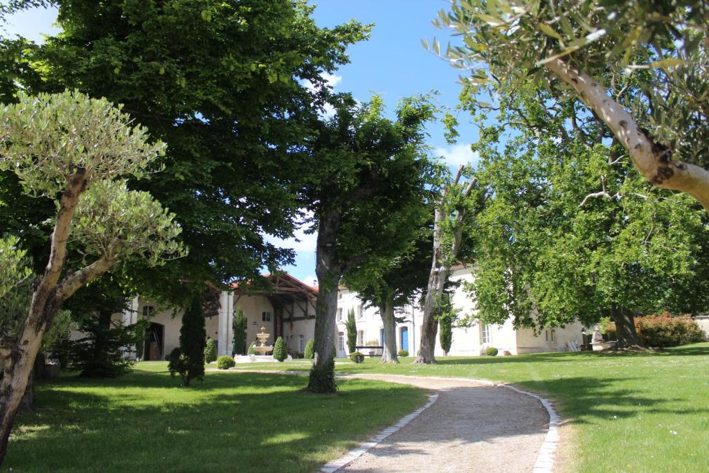 a house in the middle of a lawn with trees at Logis Domaine des Chais in Thénac