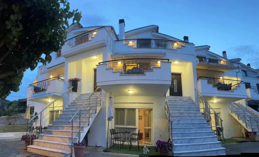 a white building with stairs in front of it at White Paradise in Paleo Tsifliki