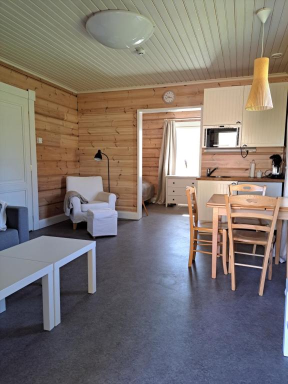 uma sala de estar com mesa e cadeiras e uma cozinha em Norrby Gård - Piian kamari em Raseborg