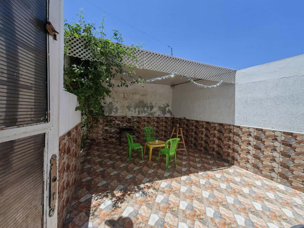 un patio con 2 sillas verdes y una mesa en MOHAMMED AIRPORT LUXURY VILLA en Deroua