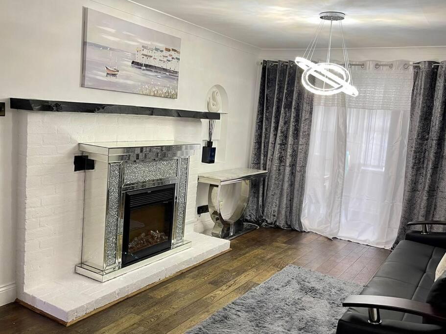 a living room with a fireplace and a couch at Spacious 4 bedroom house in Billericay
