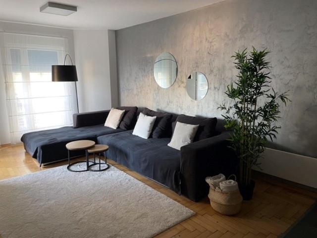 a living room with a black couch and a table at Apartment Lungomare in Pula