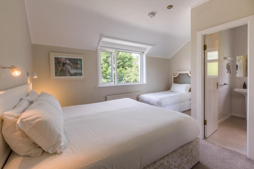 Un dormitorio con una gran cama blanca y una ventana en Lios Na Manach ECO B&B en Killarney