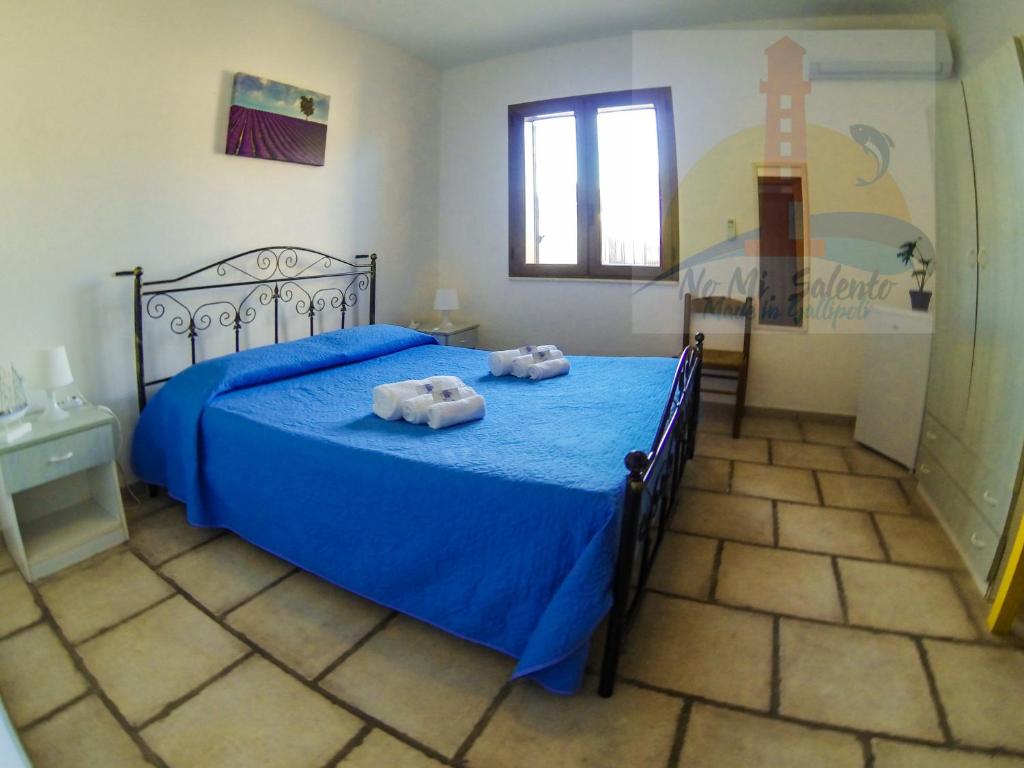 ガリポリにあるRooms & Apartments Lido degli Dei Gallipoliのベッドルーム1室(ブルーベッド1台、タオル2枚付)