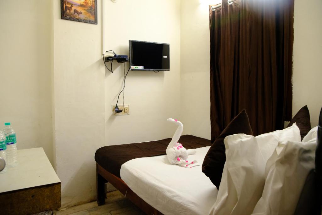 een kamer met een bed met een knuffeldier erop bij Aum Karthikeya Residency in Chennai