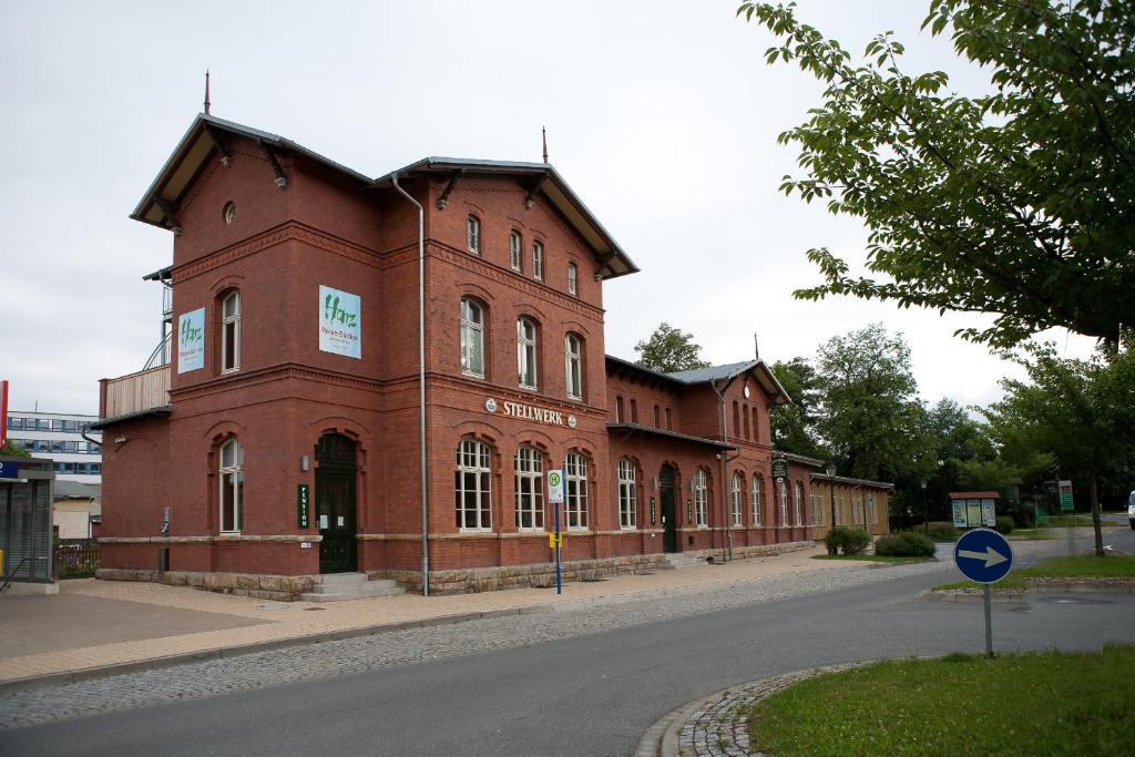 a large red brick building on the side of a street at Pension Stellwerk Ilsenburg in Ilsenburg