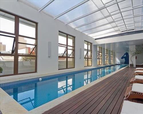 a large swimming pool in a large building at Apto 1Q 300MB Fibra Ótica Próx Shop Estação in Curitiba