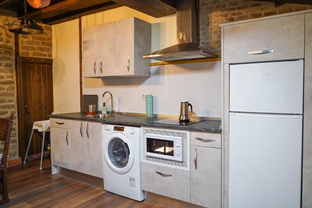 a kitchen with a washing machine and a refrigerator at La casa de la abuela Amalia in Arenas de San Pedro