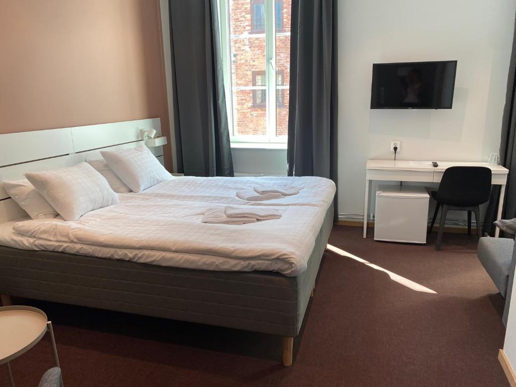 Bett in einem Zimmer mit einem Schreibtisch und einem Bett der Marke sidx sidx sidx. in der Unterkunft Ahlgrens Hotell Bed & Breakfast in Gävle
